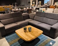 duży szary narożnik nowoczesny w salonie z drewnianym stolikiem